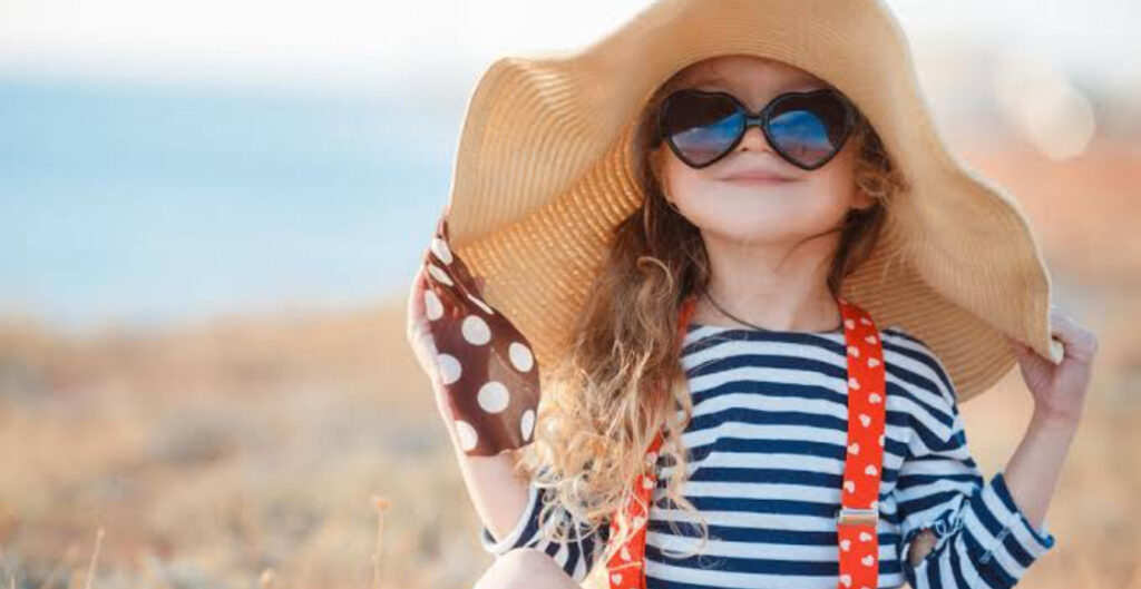criança protegida do sol com roupas e chapéu. Mesmo no inverno